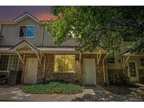 Charming townhome with stone accents, a tidy lawn, and a cozy, welcoming front porch at 2141 Coronado N Pkwy # C, Denver, CO 80229