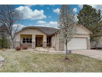 Charming single-story home with stone accents, mature trees, and a well-manicured lawn under a blue sky at 10619 N Osceola Dr, Westminster, CO 80031