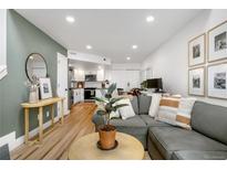 Inviting living room featuring a modern gray sofa, wood floors, and an open floorplan at 12478 W Nevada Pl # 208, Lakewood, CO 80228