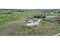 Areal view of the property showing a two-story home overlooking the lush green fairways of the golf course at 19887 Kershaw Ct, Monument, CO 80132