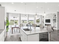 Bright kitchen features a marble island, hardwood floors, stainless steel appliances, and beautiful views at 19887 Kershaw Ct, Monument, CO 80132