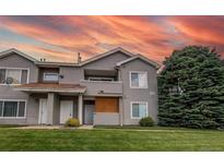 Inviting exterior showcasing a well-maintained townhouse with manicured lawn and covered balcony at 908 S Yampa St # 208, Aurora, CO 80017