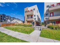 Modern townhome exterior featuring vibrant orange accents and well-maintained landscaping on a sunny day at 1216 Perry St, Denver, CO 80204