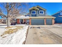 Two-story home featuring a three-car garage and blue siding at 4702 S Biscay Ct, Aurora, CO 80015