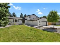 Charming two-story home featuring a manicured lawn, mature trees, and a two car attached garage at 3773 E Mineral Pl, Centennial, CO 80122