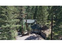 Charming home nestled among trees with stone accents and an attached garage for a secluded, woodsy feel at 30094 Upper Bear Creek Rd, Evergreen, CO 80439