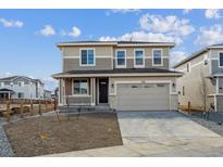 Two-story home with a two-car garage, covered porch, and a front yard ready for landscaping at 1324 Sienna Peak Cir, Erie, CO 80516