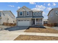 Charming two-story home with a gray exterior, stone accents, an attached two-car garage, and a well-manicured lawn at 841 Alpine Ridge St, Erie, CO 80516
