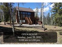 Inviting two-story brown home featuring a deck and stairs in a wooded area, promoting its welcoming outdoor spaces at 10438 Sunlight Ln, Conifer, CO 80433