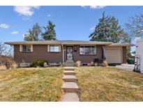 Charming brick home with a well-maintained front yard and inviting walkway to the front door at 5118 S Osceola St, Littleton, CO 80123