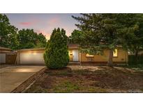 Charming single-story home with brick facade, well-manicured landscaping, and attached garage at 1235 S Benton St, Lakewood, CO 80232