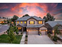 Stunning two-story home with a three-car garage and beautifully landscaped front yard at sunset at 6728 S Catawba Way, Aurora, CO 80016