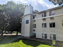 Exterior view of a multi-story building with light siding and well-maintained green lawn at 17361 E Mansfield Ave # 532R, Aurora, CO 80013
