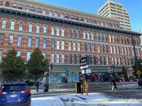 Historical brick building featuring intricate architectural details and street-level retail spaces at 1555 California St # 302, Denver, CO 80202