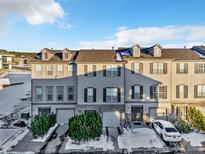 Three story townhouses with attached garages and snowy landscaping at 909 Burning Bush Pt, Monument, CO 80132