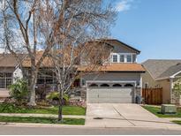 Charming two-story home features a well-maintained lawn, a two-car garage, and attractive landscaping at 6055 W Progress Ave, Littleton, CO 80123