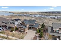 Beautiful two-story home with a well-manicured lawn and lake view at 26741 E Arbor Dr, Aurora, CO 80016