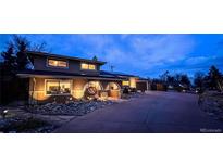 Charming home with a cozy front porch and beautiful landscaping at twilight at 9201 W Tennessee Ave, Lakewood, CO 80226