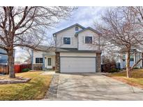 Charming two-story home with a two-car garage, stone accents, and a well-maintained front yard at 11537 Macon St, Commerce City, CO 80640