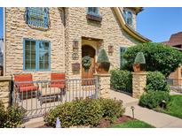 Charming stone home exterior featuring a cozy front porch with seating and manicured landscaping at 639 S Williams St, Denver, CO 80209