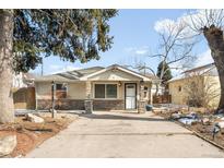 Charming single-story home featuring stone accents, a well-maintained lawn, and a paved driveway at 404 S Jasmine St, Denver, CO 80224