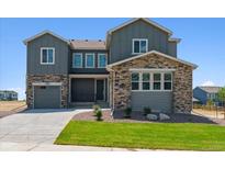 Charming two-story home featuring a gray exterior with a stone accent and an attached garage at 13765 Emerald Lake St, Parker, CO 80138