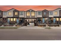Modern townhomes featuring brick facade, blue doors, and manicured landscaping at 5469 S Curtice St # E, Littleton, CO 80120