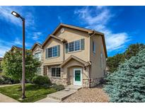 Inviting two-story home with stone accents, a well-manicured lawn, and lush landscaping at 12783 Ivy St, Thornton, CO 80602