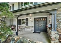 Charming covered porch with stone accents leads to a stylish front door, enhancing curb appeal at 4338 S Alton St, Greenwood Village, CO 80111