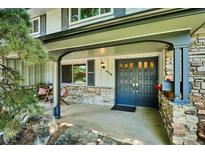Charming covered front porch with stone accents and seating area, perfect for relaxing outdoors at 4338 S Alton St, Greenwood Village, CO 80111
