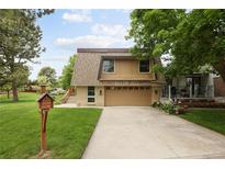 Charming home featuring a well-manicured lawn, two-car garage, and inviting curb appeal at 141 S Upham Ct, Lakewood, CO 80226
