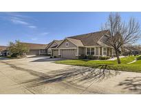 Charming home featuring an attached two-car garage, well-maintained lawn, and inviting curb appeal at 7774 S Biloxi Way, Aurora, CO 80016
