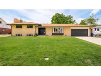 Charming, single-story brick home with a lush lawn and a covered front porch at 85 S Flower St, Lakewood, CO 80226