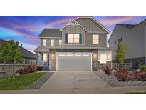 Beautiful two-story home features a stone facade, two-car garage, and well-manicured lawn at 7166 S Vandriver Way, Aurora, CO 80016