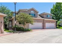 Charming townhome with a two-car garage, inviting curb appeal, and landscaped front yard on a sunny day at 2330 S Salem Cir, Aurora, CO 80014