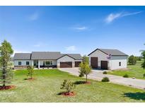 A bright ranch-style home with a large garage, a long driveway, and a well-manicured front lawn at 3047 Deer Creek Ranch Loop, Parker, CO 80138