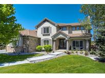 Inviting front exterior showcasing a landscaped yard, stone accents, and a welcoming entrance with stone pillars at 24031 E Hinsdale Pl, Aurora, CO 80016