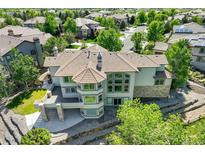 Aerial view of a backyard featuring a stone terrace and elevated deck with elegant neutral paint and roofing at 24031 E Hinsdale Pl, Aurora, CO 80016