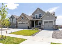 Charming two-story home featuring stone accents, well-manicured lawn, and an inviting entrance at 4918 Preserve Pl, Firestone, CO 80504