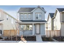 Two-story craftsman style home with gray siding, front porch, and landscaped yard at 6355 N Emporia Ct, Denver, CO 80238