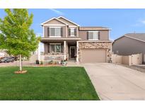 Charming two-story home with a covered front porch, stone accents, and a well-manicured lawn at 6922 Vermillion St, Frederick, CO 80530