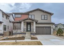 Charming two-story home with a modern gray exterior and stone accents and well-maintained landscaping at 5575 Moosehead Cir, Longmont, CO 80503
