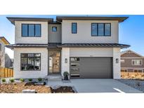 Modern two-story home featuring a gray garage door and a manicured front yard at 936 Sunflower St, Louisville, CO 80027
