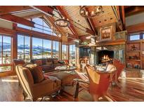 Spacious living room with wood beams, stone fireplace, and mountain views at 220 Cottonwood Cir, Breckenridge, CO 80424