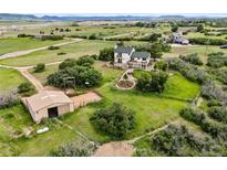 Expansive property features a home, barn, and paddock, all nestled within a vast landscape with distant mountain views at 225 Briscoe Ln, Castle Rock, CO 80109