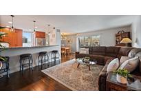 Open-concept living room showcasing hardwood floors and kitchen access with granite countertops and stainless appliances at 460 S Marion Pkwy # 251, Denver, CO 80209