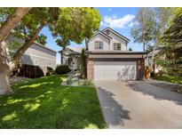 Charming two-story home with a well-manicured lawn, mature trees, and a spacious two-car garage at 7345 W 97Th Pl, Broomfield, CO 80021