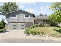 Charming gray home with a well-manicured lawn, two-car garage, and a bright red front door at 9383 W Colorado Ave, Lakewood, CO 80232