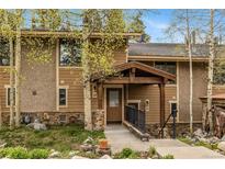 Inviting exterior showcasing the home's entrance, with stone accents and mature trees at 877 Airport Rd # 19, Breckenridge, CO 80424