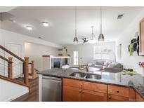 Open-concept living room featuring a fireplace and stylish decor at 4100 Albion St # 205, Denver, CO 80216